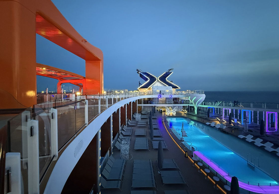 The pool deck of The Edge cruise ship, with the orange-trimmed Flying Carpet bar and restaurant pictured on the left.