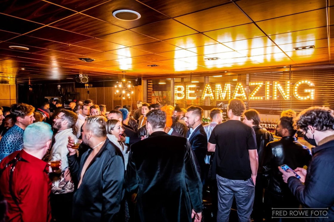 The New Year's Eve party at Chambers Eat+ Drink at Phoenix Hotel in 2021, filled with a buzzing crowd and a glowing sign that reads 