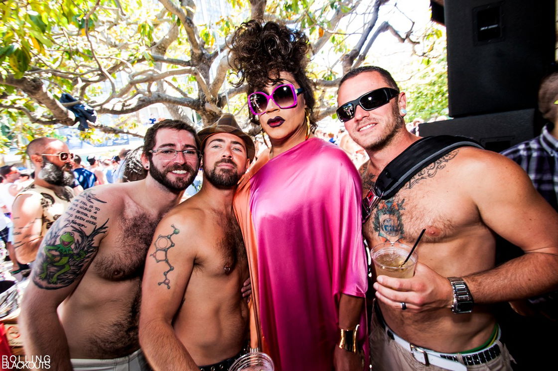 Juanita MORE! poses with a group of shirtless men at a Pride party in 2012.